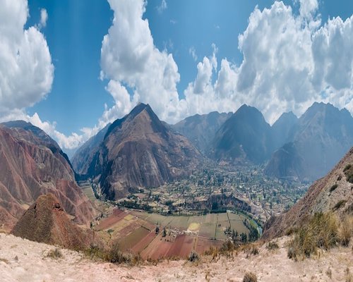 A high altitude valley town in the Peruvian mountains surrounded by dry slopes and bright sunlight